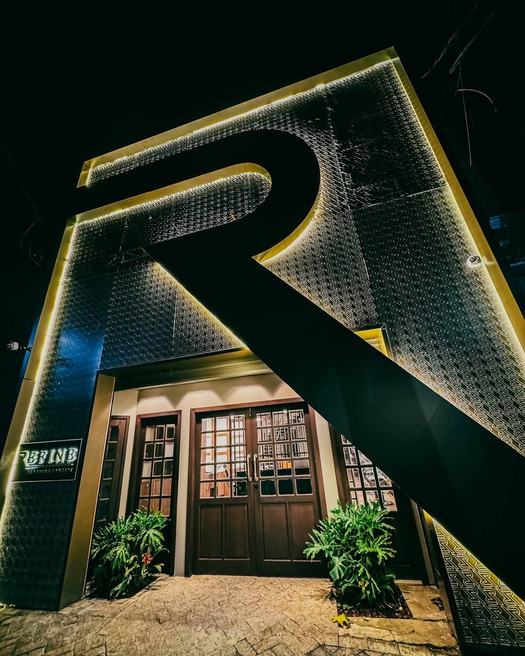 Fachada da Refine com letra R iluminada